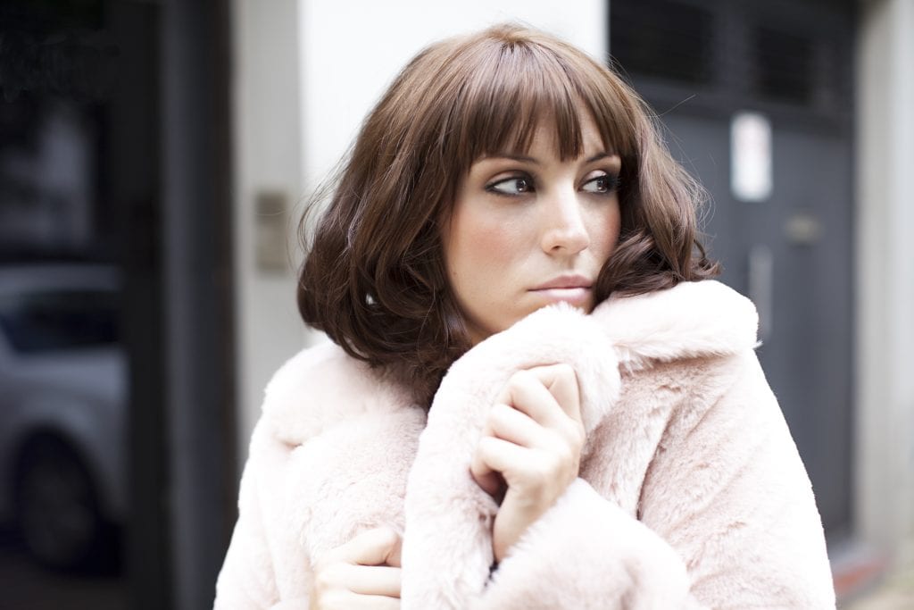 brunette woman looking sideways with fur coat - pH Plex